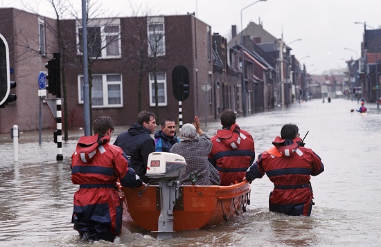 Wateroverlast in Venlo, foto genomen op 29-01-1995, hulpverleners varen met een rubberboot over een ondergelopen straat