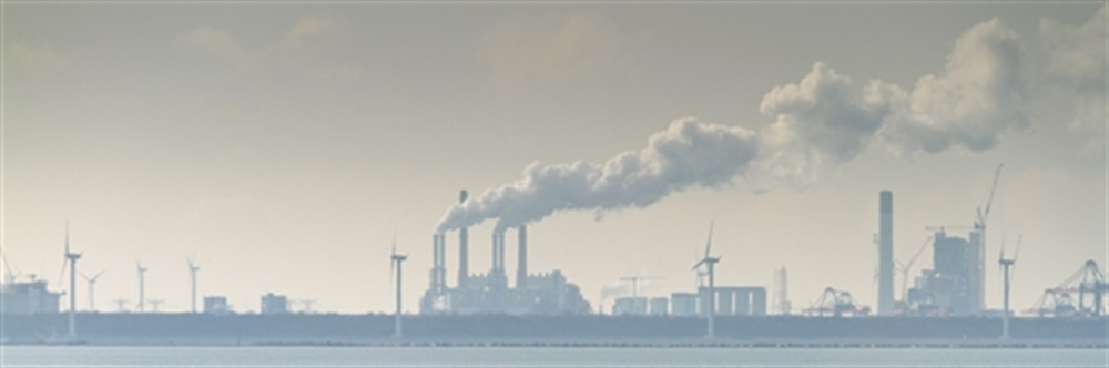 Industrie aan de kust met schoorstenen en rook