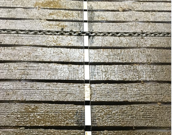 Afbeelding van de vloer waarbij de gleuf tussen de vloerelementen is dichtgemaakt met het inlegprofiel, waarbij de zijkanten van de inleg profielen ook dicht zijn