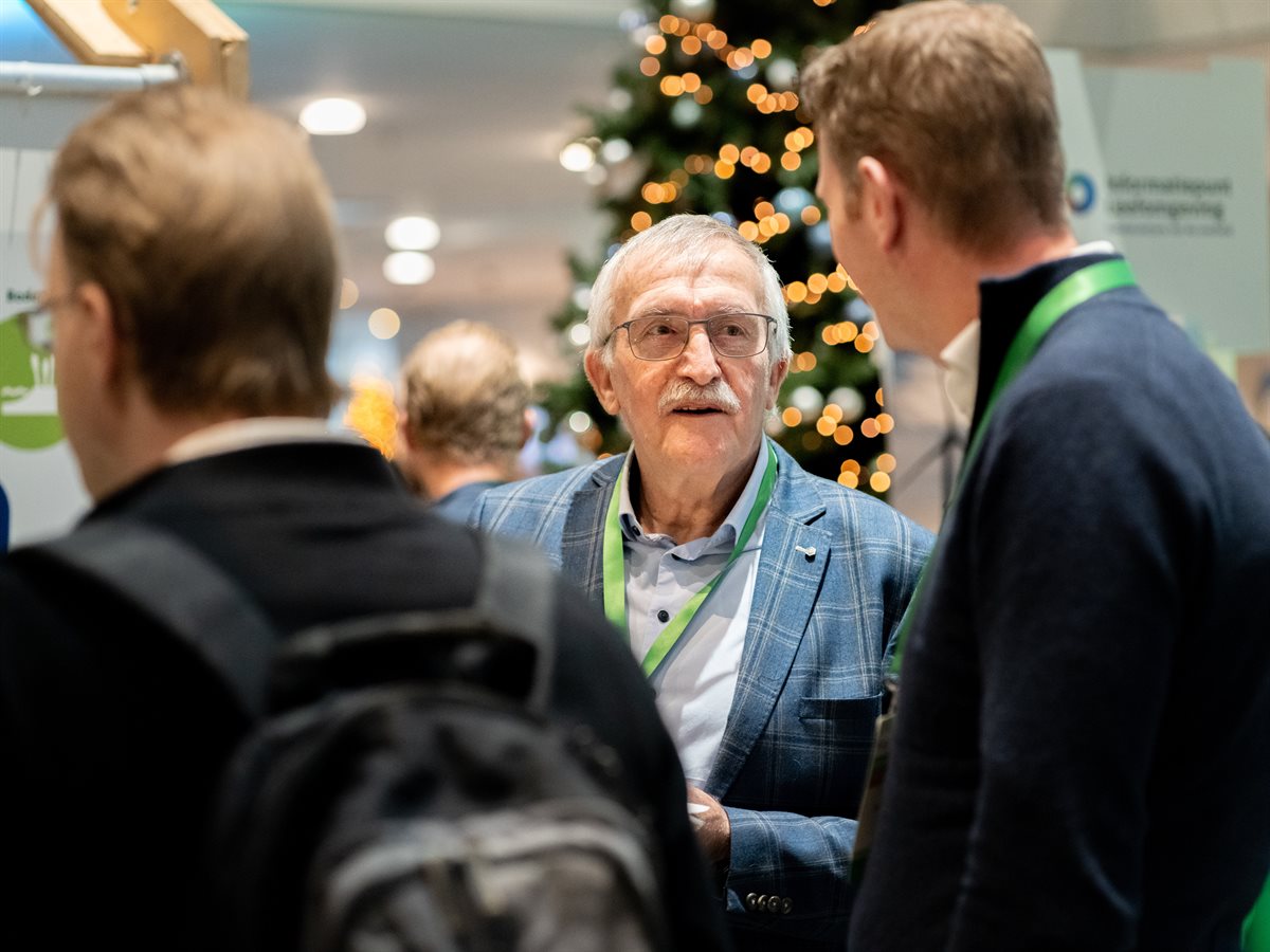 Oudere en jongere deelnemer praten op netwerkplein